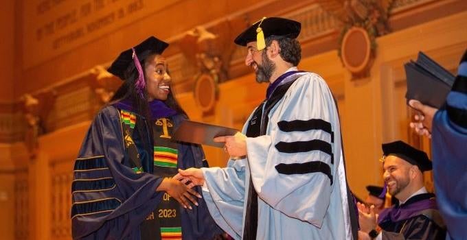 master's student receiving diploma during Pitt Law graduation