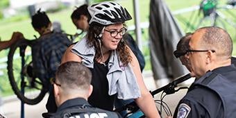 student talks with campus police during bike to work safety event