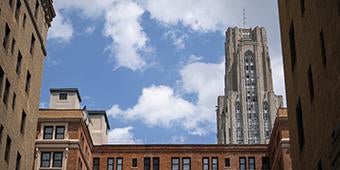 view of cathedral of learning behind campus buildings