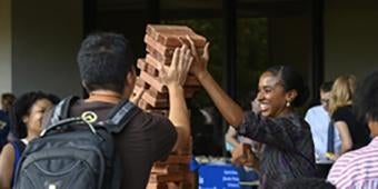 students playing Jenga at grad orientation picnic