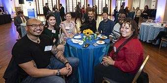 students gathered around table celebrating Graduate Student Honors Convocation