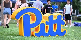 Pitt logo sculpture on lawn