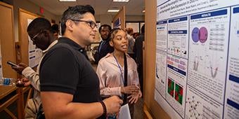 student shares research during poster session