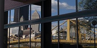 Pittsburgh buildings and bridge reflected in glass window