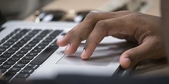 closeup of hand on laptop keyboard