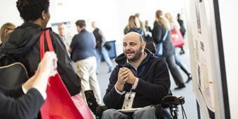 Seating Symposium participant sharing his research during poster session