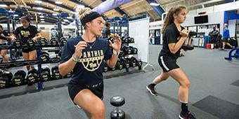 students exercising in weight room