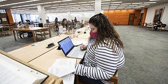 student working at a table in Hillman Library