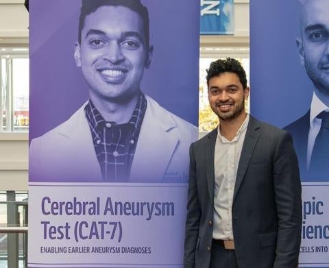 Adi Mittal standing by a poster