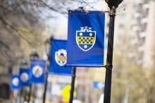 Banners showing Pitt shield on lampposts on campus